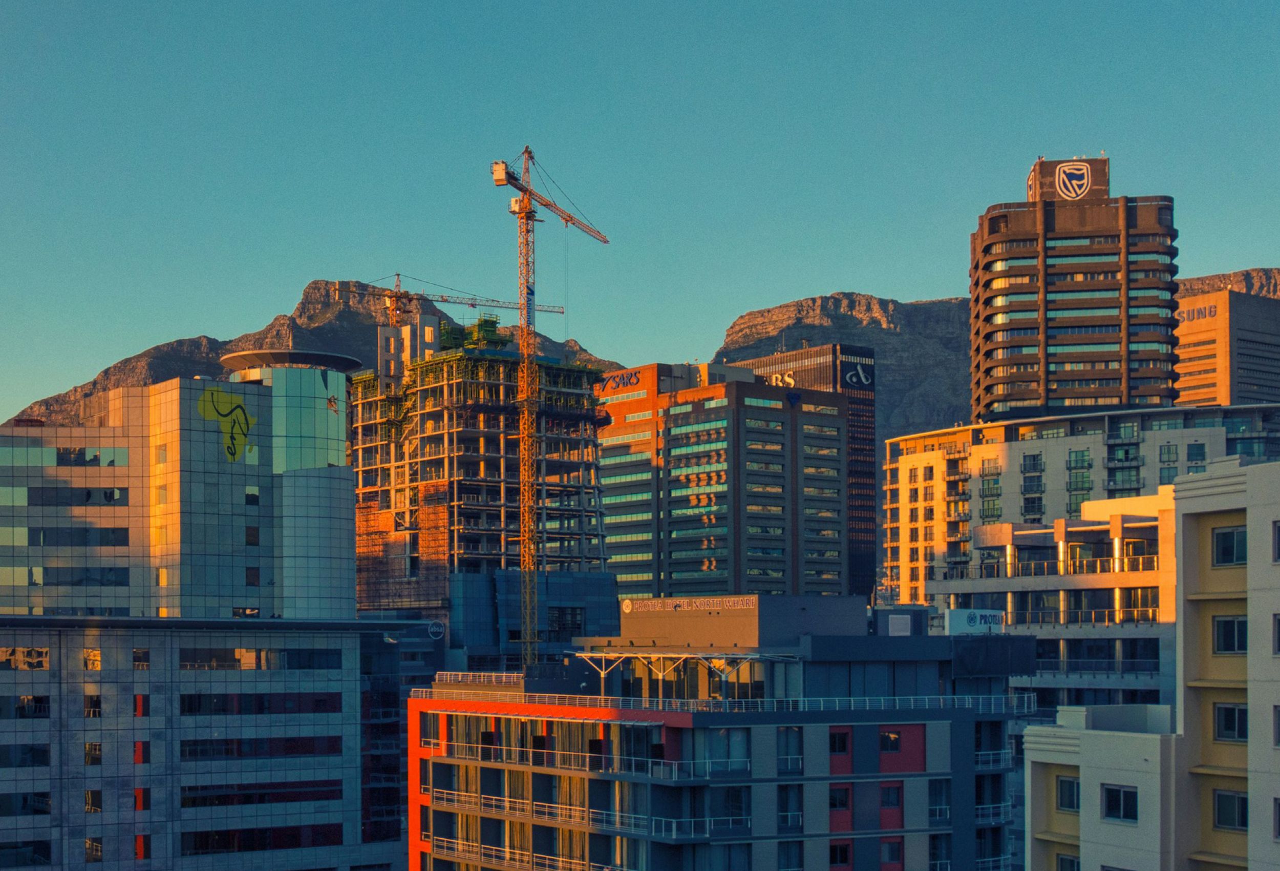 City apartment blocks with mountains and blue sky behind