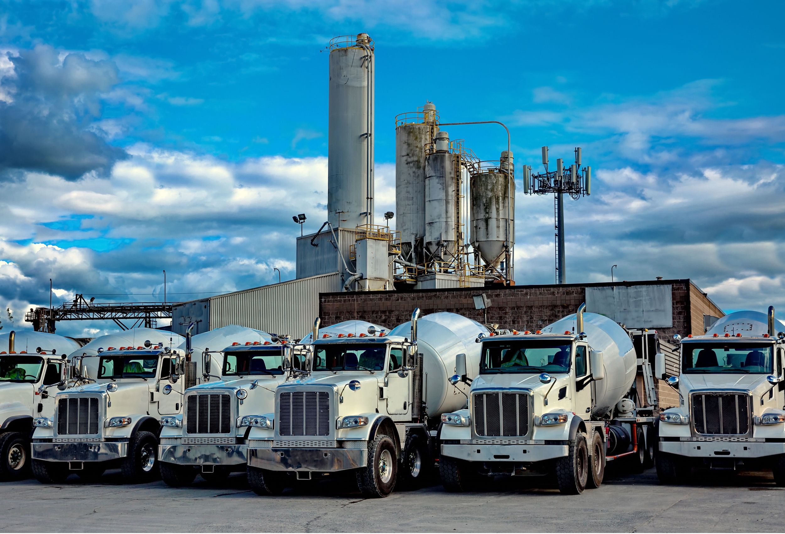 Cement mixer lorries in front of industrial buildings