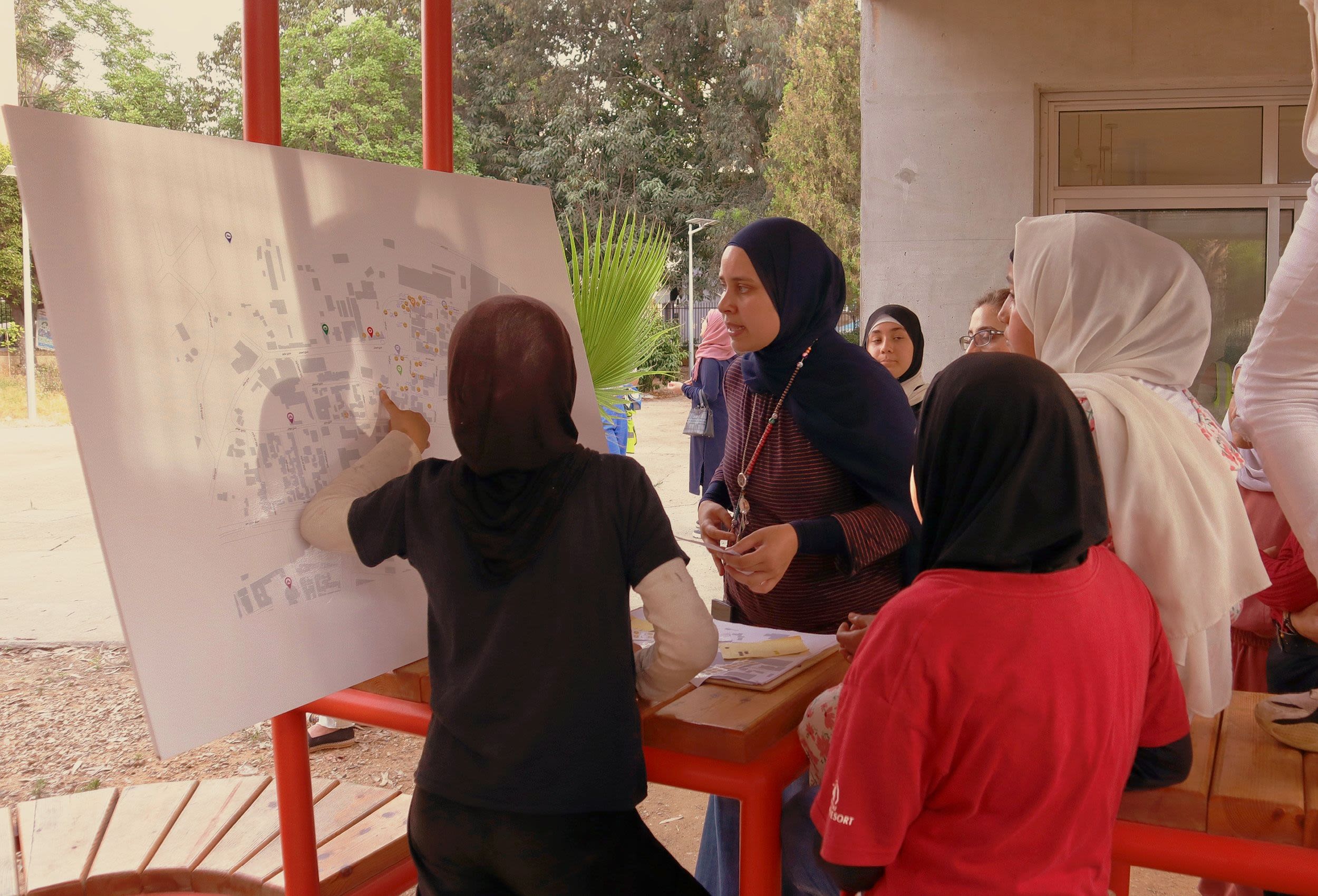 Group of young women gathered around a large map