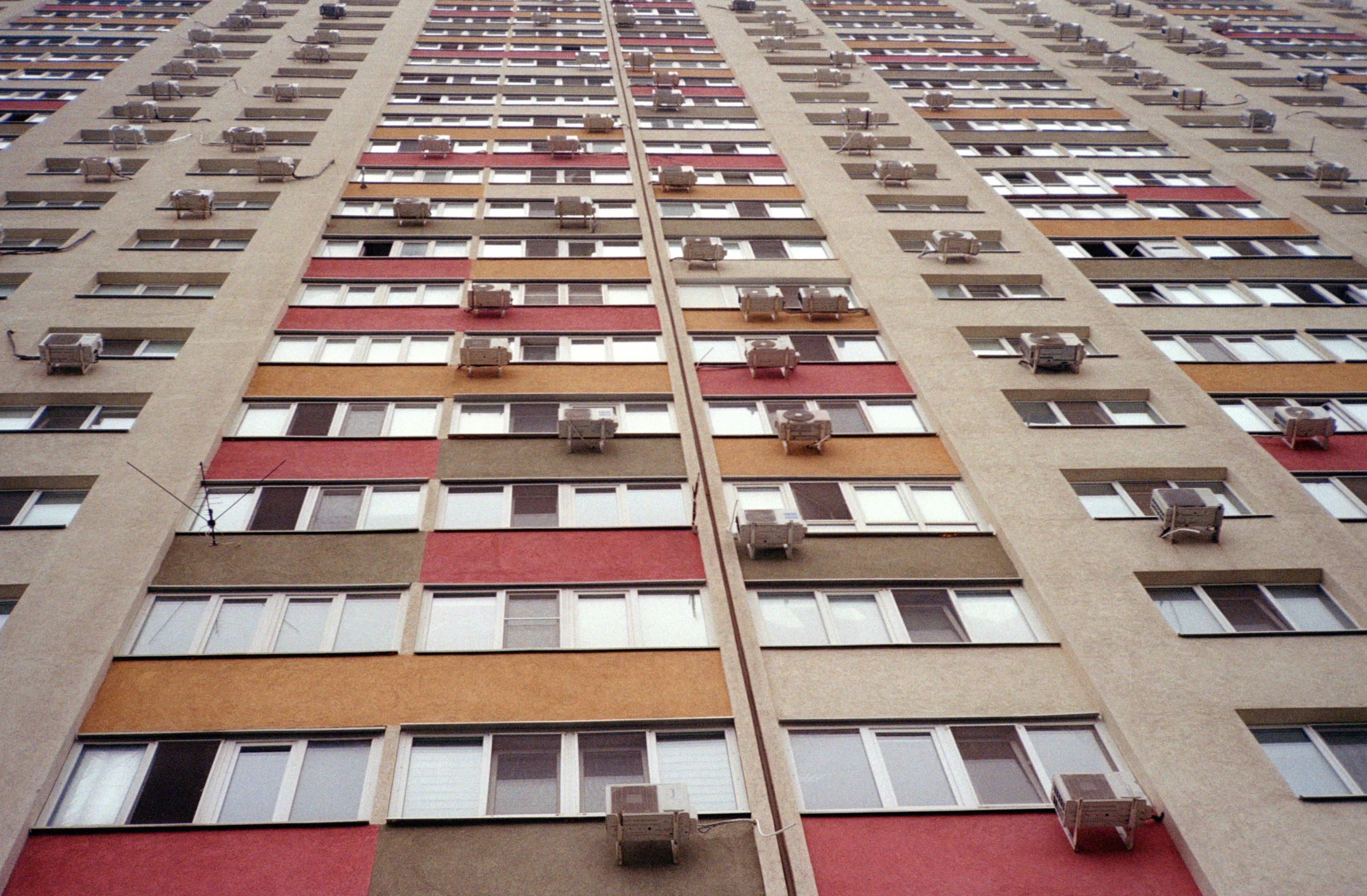 Tall apartment building with many windows and balconies.