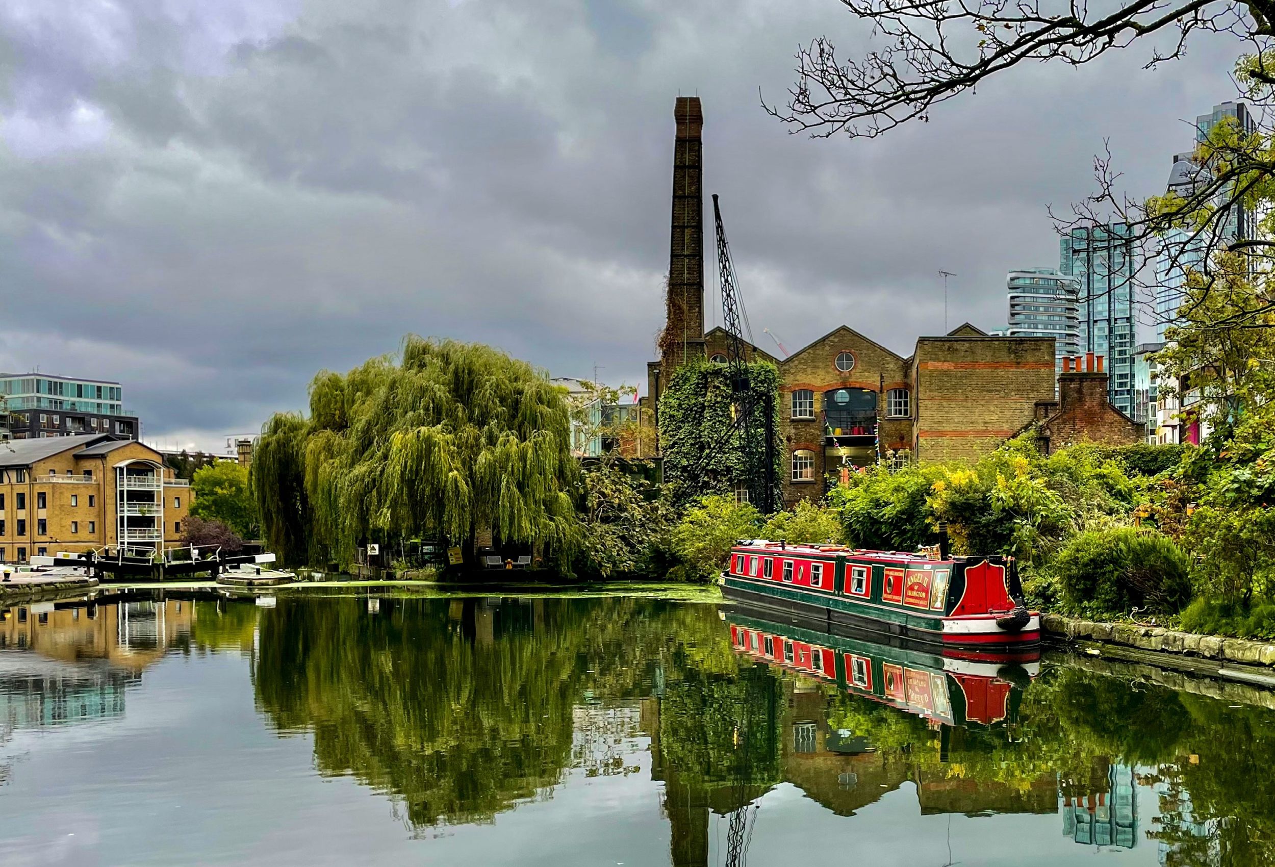 Islington canal with boat, and houses and trees on the bank