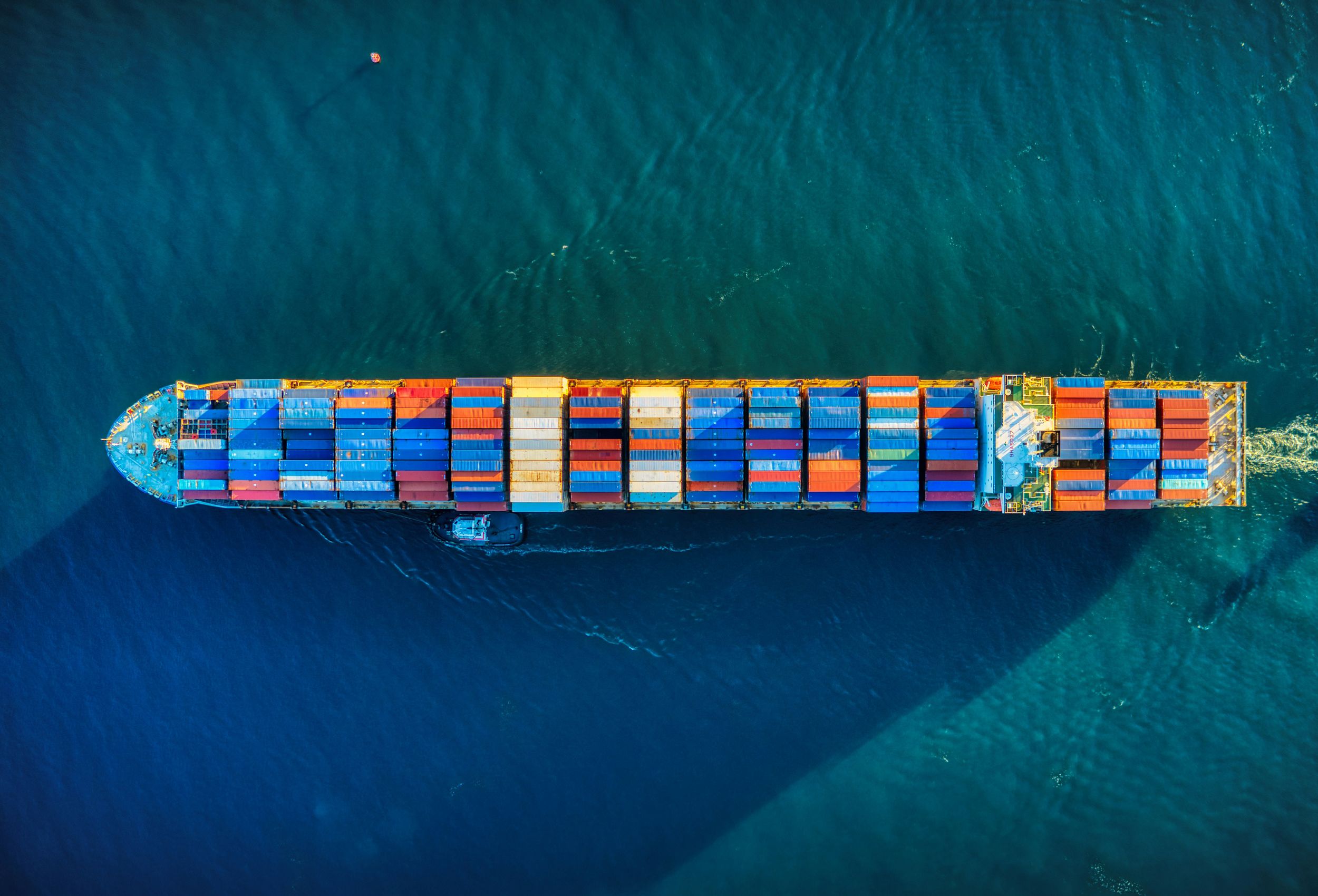 Aerial view of a ship with colourful containers on the sea
