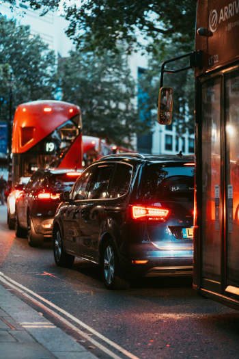 a city street filled with traffic next to tall buildings