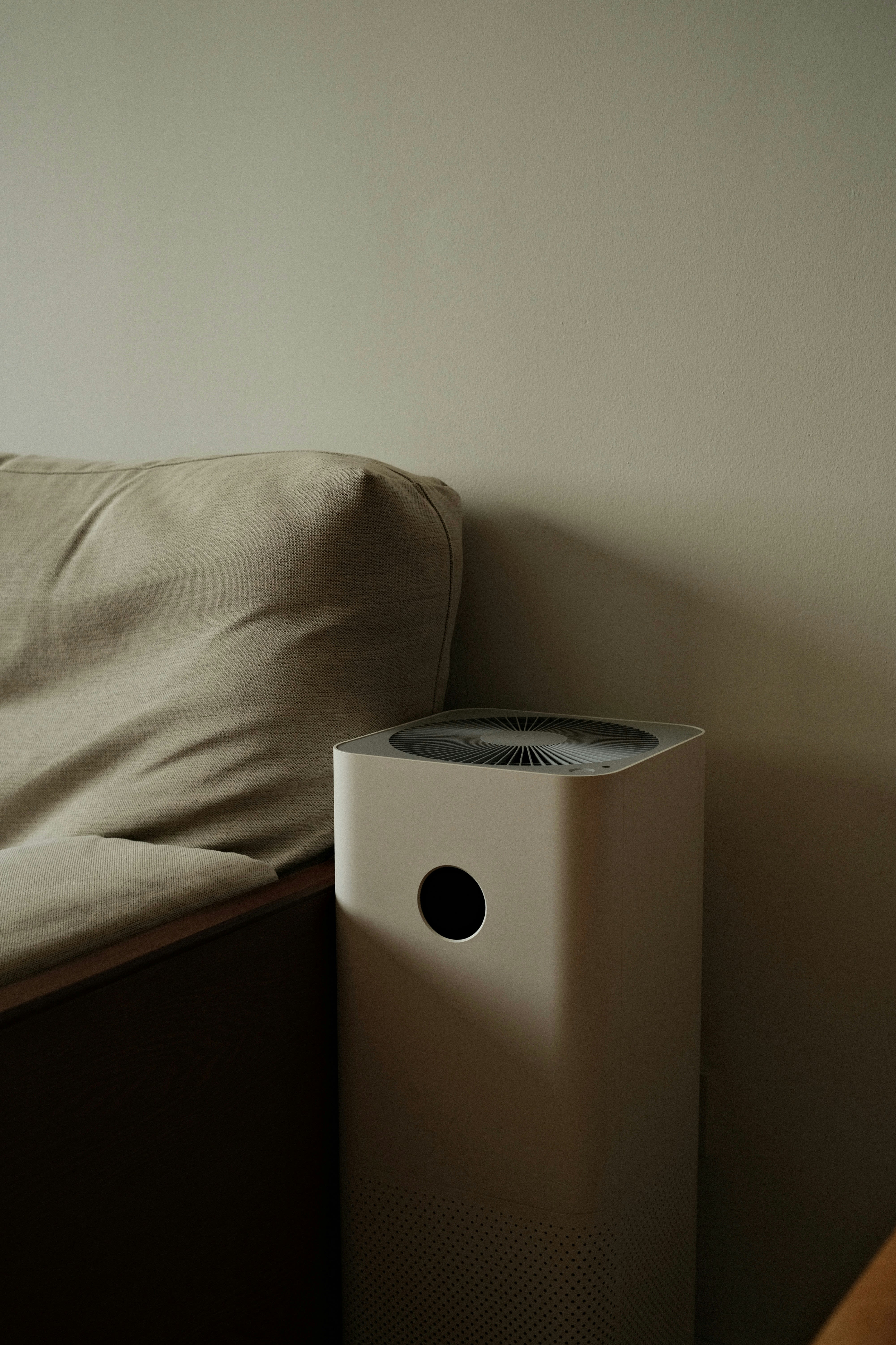 a white air conditioner sitting on top of a bed