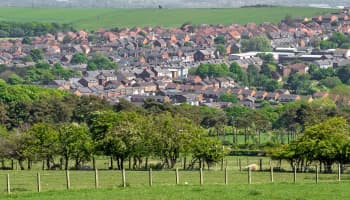 View of a village surrounded by green fields