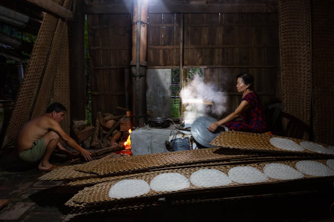 Man and woman cooking in wooden hut