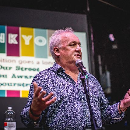 Photo of Dom Murphy speaking into a microphone