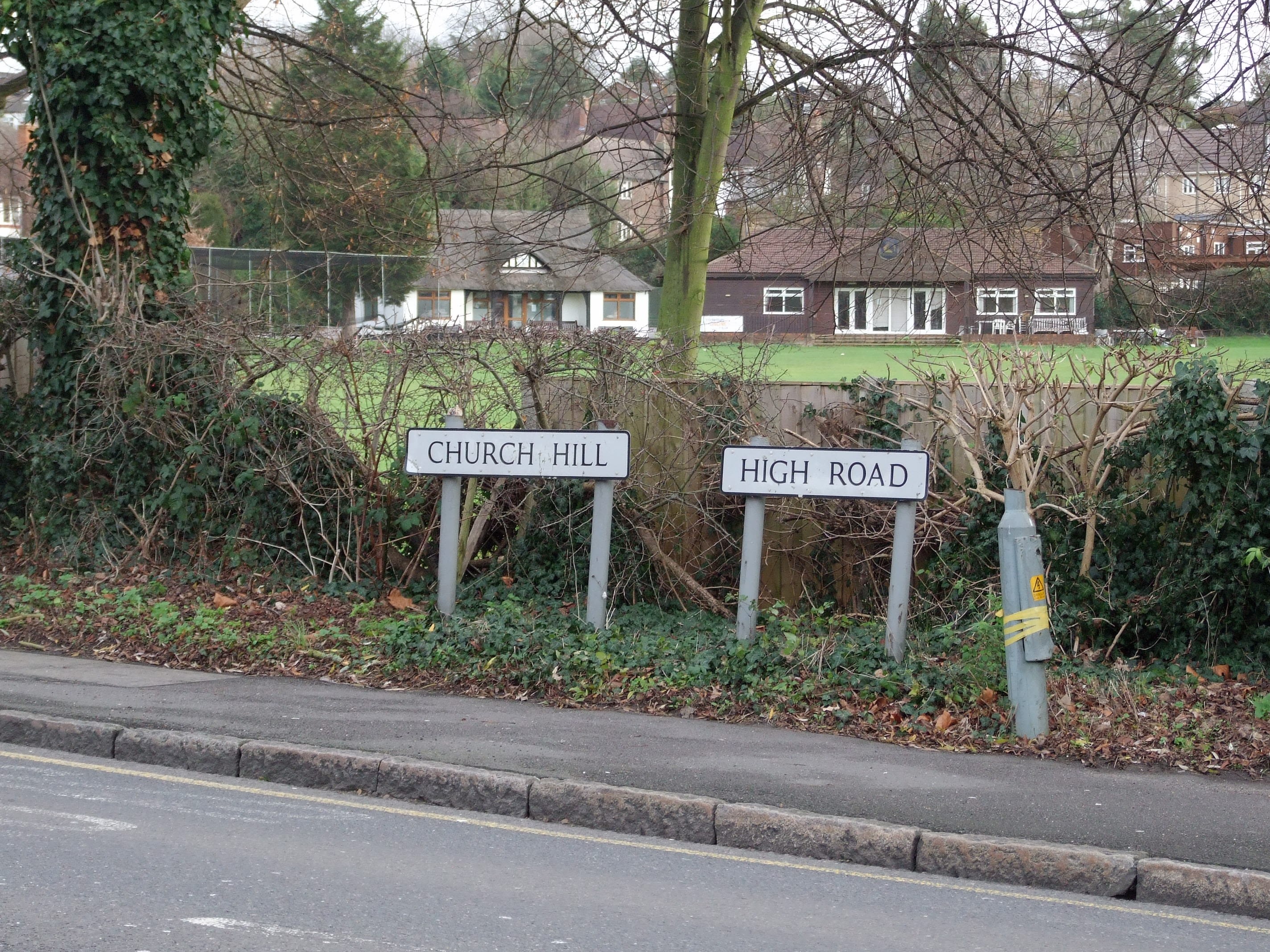 Road signs in Loughton, UK, showing where Church Hill meets High Road. 